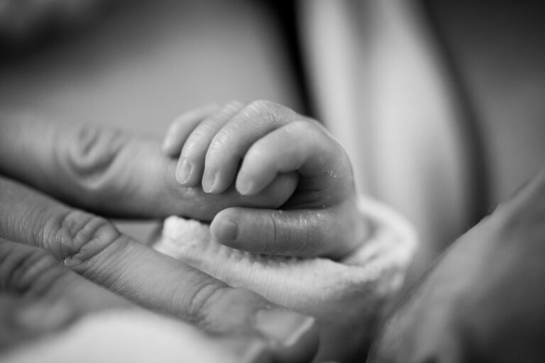 Main d'un bébé qui prend le doigt de sa mère